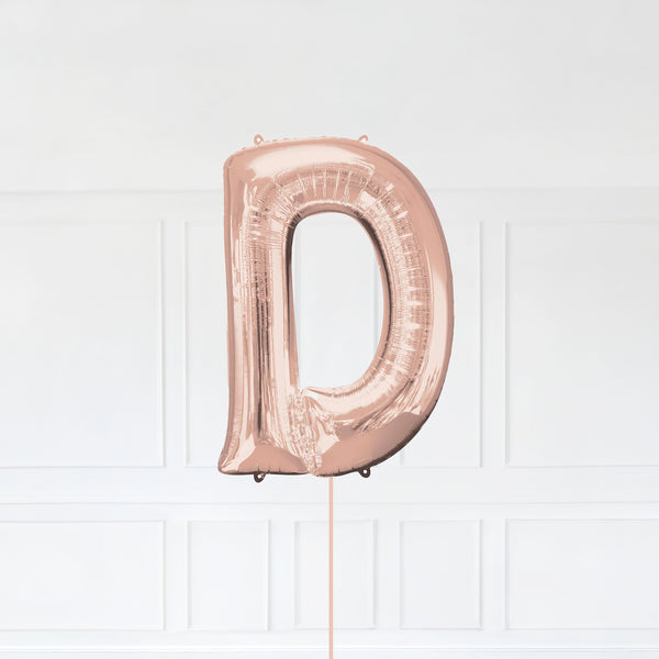 Letter D Foil Balloon Inflated With Helium, Rose Gold Color Letter D with Balloon String and Balloon Weight.