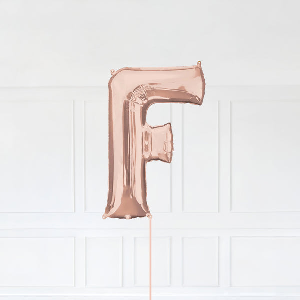 Letter F Foil Balloon Inflated With Helium, Rose Gold Color Letter F with Balloon String and Balloon Weight.