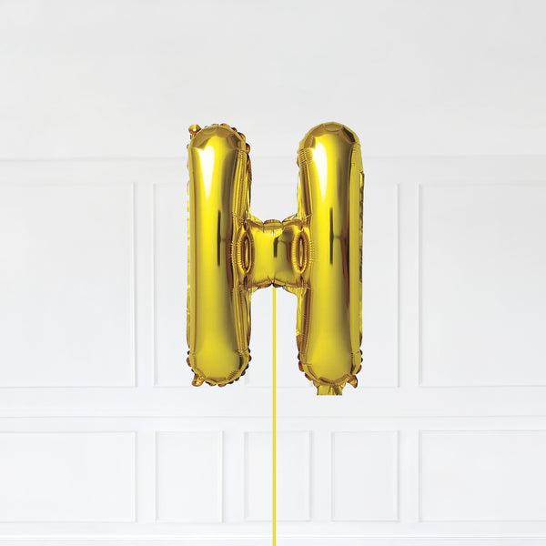 Letter H Foil Balloon Inflated With Helium, Gold Color Letter H with Balloon String and Balloon Weight.