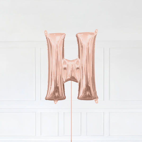 Letter H Foil Balloon Inflated With Helium, Rose Gold Color Letter H with Balloon String and Balloon Weight.