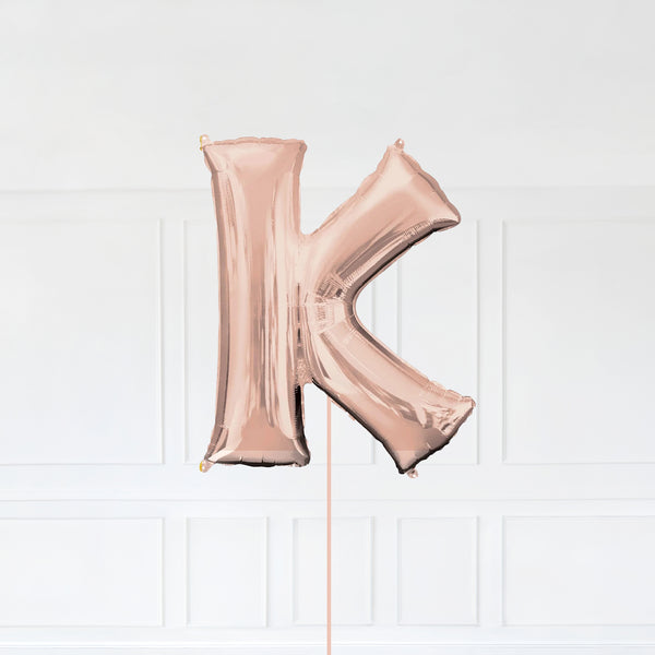 Letter K Foil Balloon Inflated With Helium, Rose Gold Color Letter K with Balloon String and Balloon Weight.