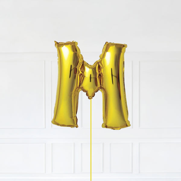 Letter M Foil Balloon Inflated With Helium, Gold Color Letter M with Balloon String and Balloon Weight.