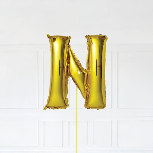 Letter N Foil Balloon Inflated With Helium, Gold Color Letter N with Balloon String and Balloon Weight.