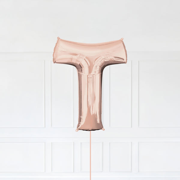 Letter T Foil Balloon Inflated With Helium, Rose Gold Color Letter T with Balloon String and Balloon Weight.