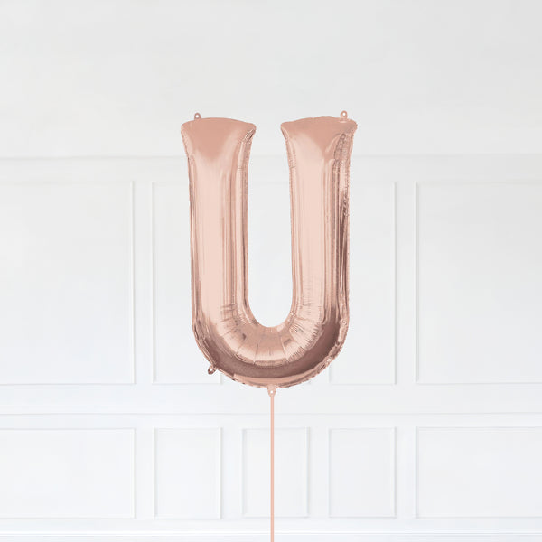 Letter U Foil Balloon Inflated With Helium, Rose Gold Color Letter U with Balloon String and Balloon Weight.