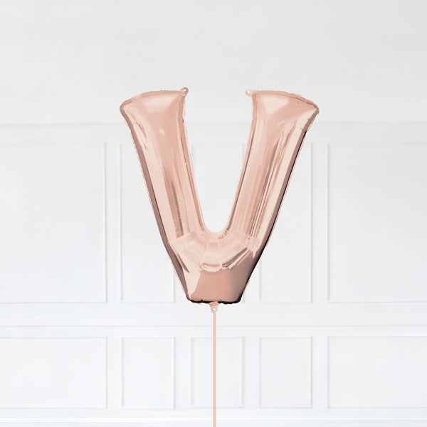 Letter V Foil Balloon Inflated With Helium, Rose Gold Color Letter V with Balloon String and Balloon Weight.