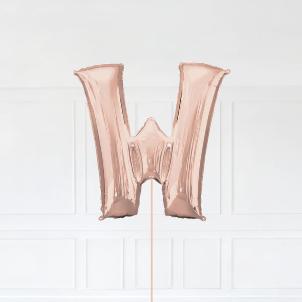 Letter W Foil Balloon Inflated With Helium, Rose Gold Color Letter W with Balloon String and Balloon Weight.