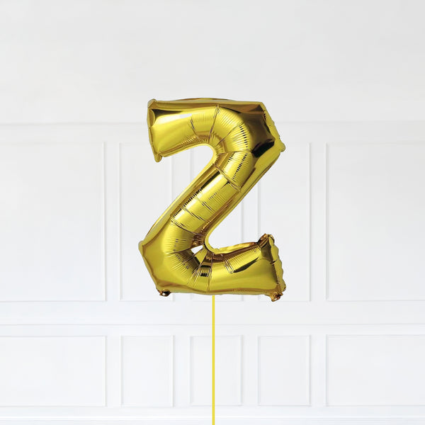 Letter Z Foil Balloon Inflated With Helium, Gold Color Letter Z with Balloon String and Balloon Weight.