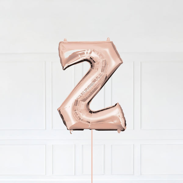 Letter Z Foil Balloon Inflated With Helium, Rose Gold Color Letter Z with Balloon String and Balloon Weight.